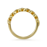 Side view of Lira swirl bezel diamond band with seven 2.0 mm round diamonds in open swirl bezels on a 1.7 mm slender low-profile band. Shown in 18k yellow gold