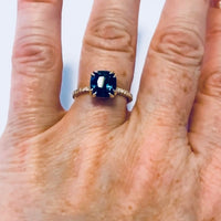 Face down view on model 18K Yellow Gold Cushion Cut Peacock Blue Spinel Engagement Ring