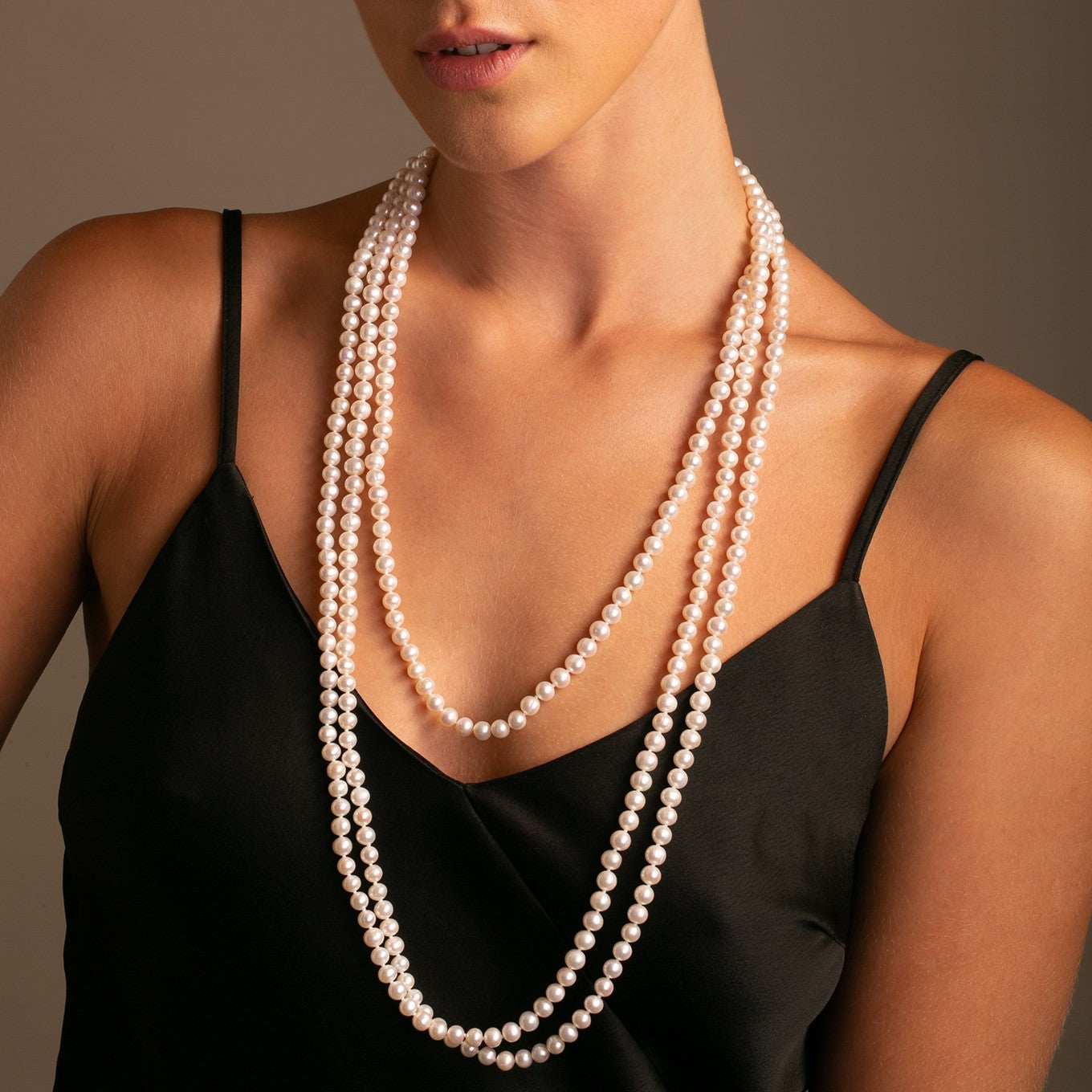 On-model: 100 cm white freshwater pearls layered as  as a three-row necklace.
