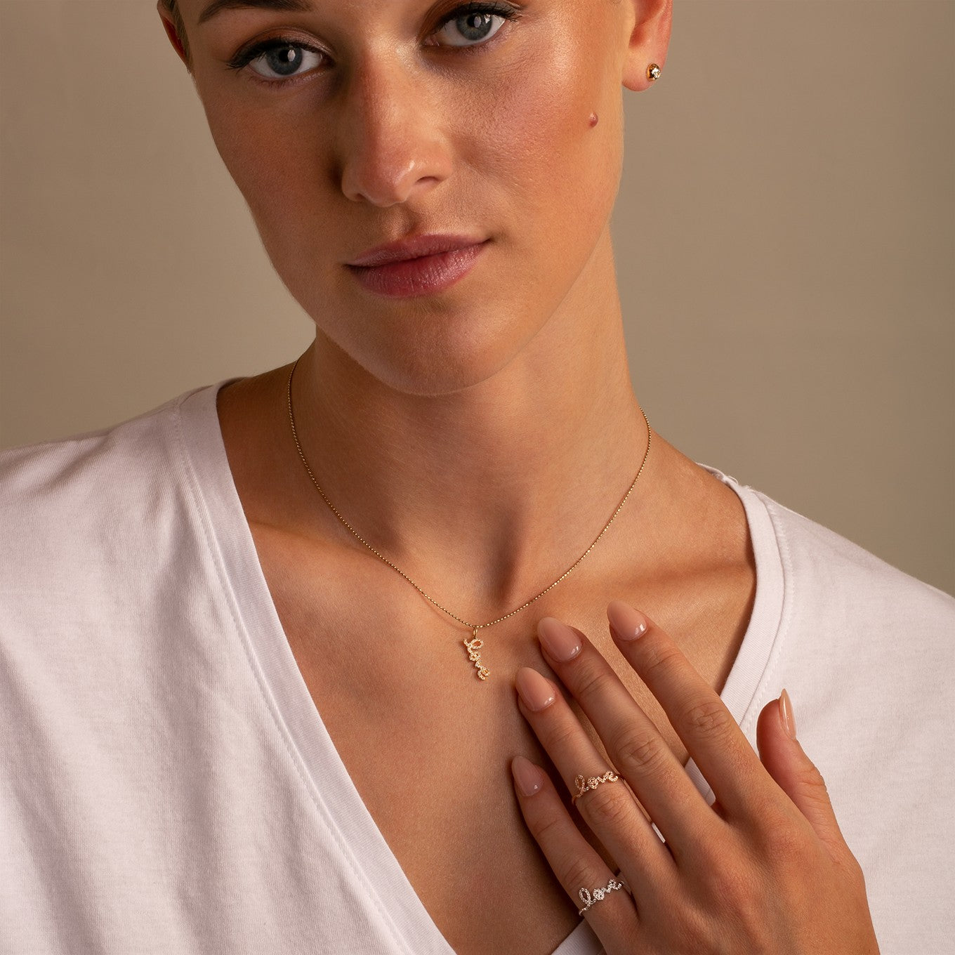 Sydney Evan 14K Yellow Vertical Small Gold and Diamond Love Pendant Necklace on model styled with Diamond Studs 