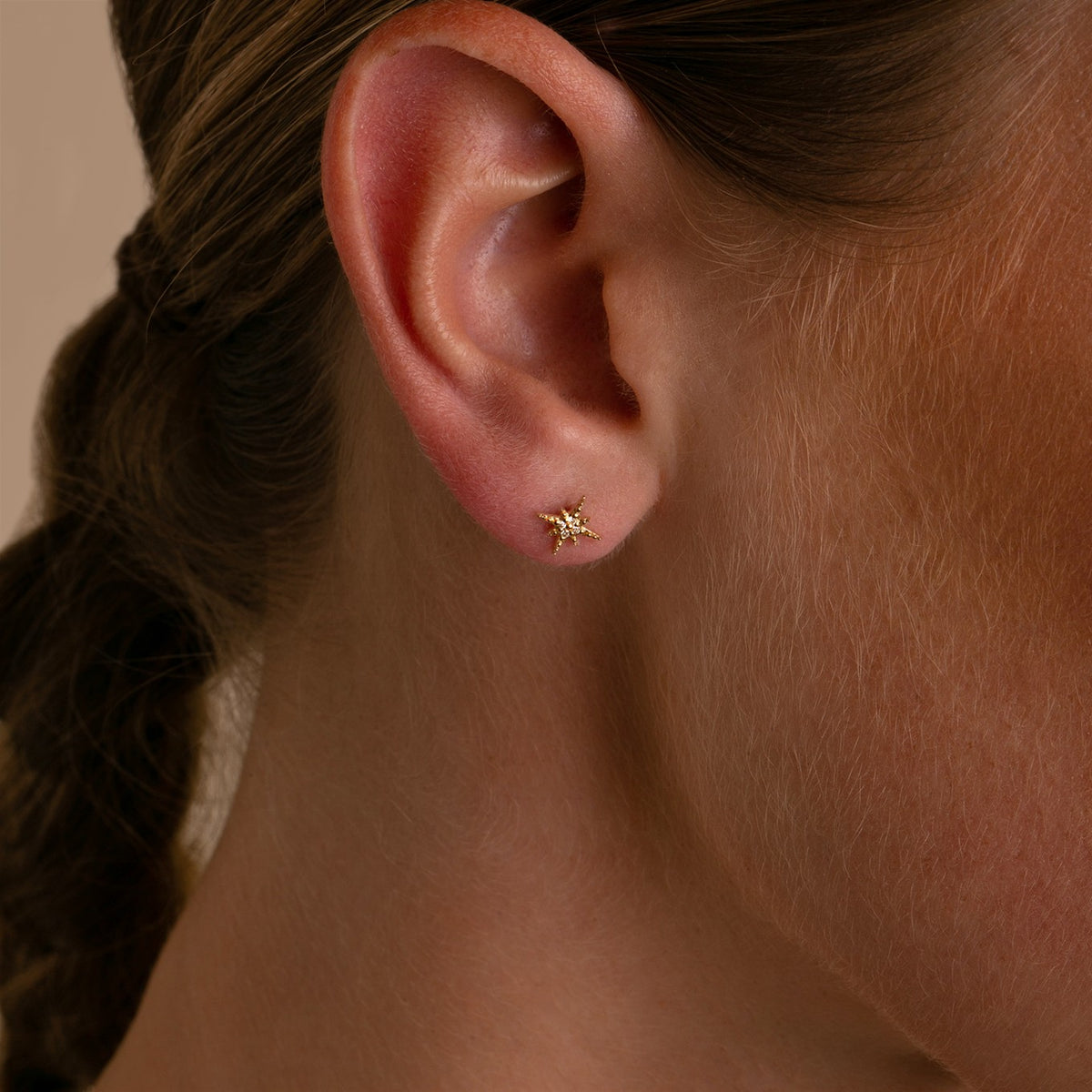Sydney Evan Mini Starburst 14-karat gold diamond earrings on model to show size and scale.