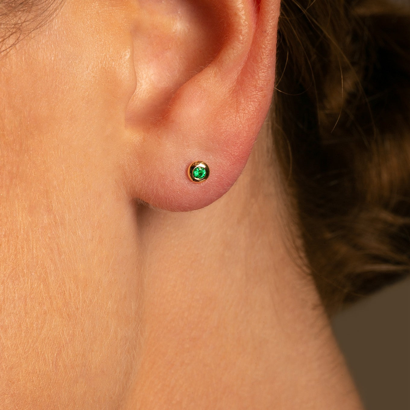 Close up detail Shop 14k Yellow Gold Micro Round Domed Bezel-Set Emerald Stud Earrings