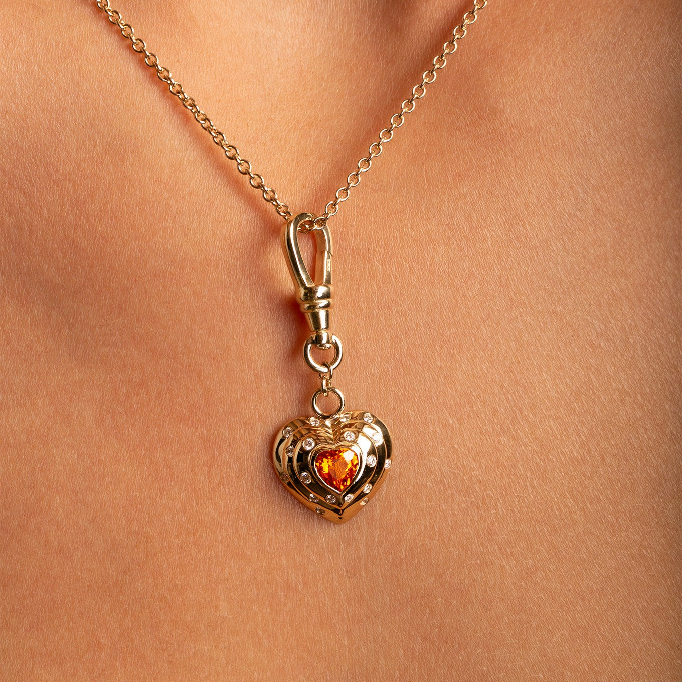 14k Yellow Gold Orange Spessartite Garnet Diamond Heart Charm with Vintage-Inspired Dog Clip close up on model