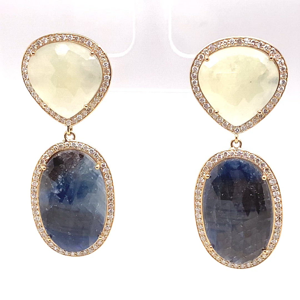 video of natural sapphire slice earrings are one of a kind, featuring a beautiful warm cream hue slice, combined with a navy grey slice set with a halo of diamonds in a high polished yellow gold setting