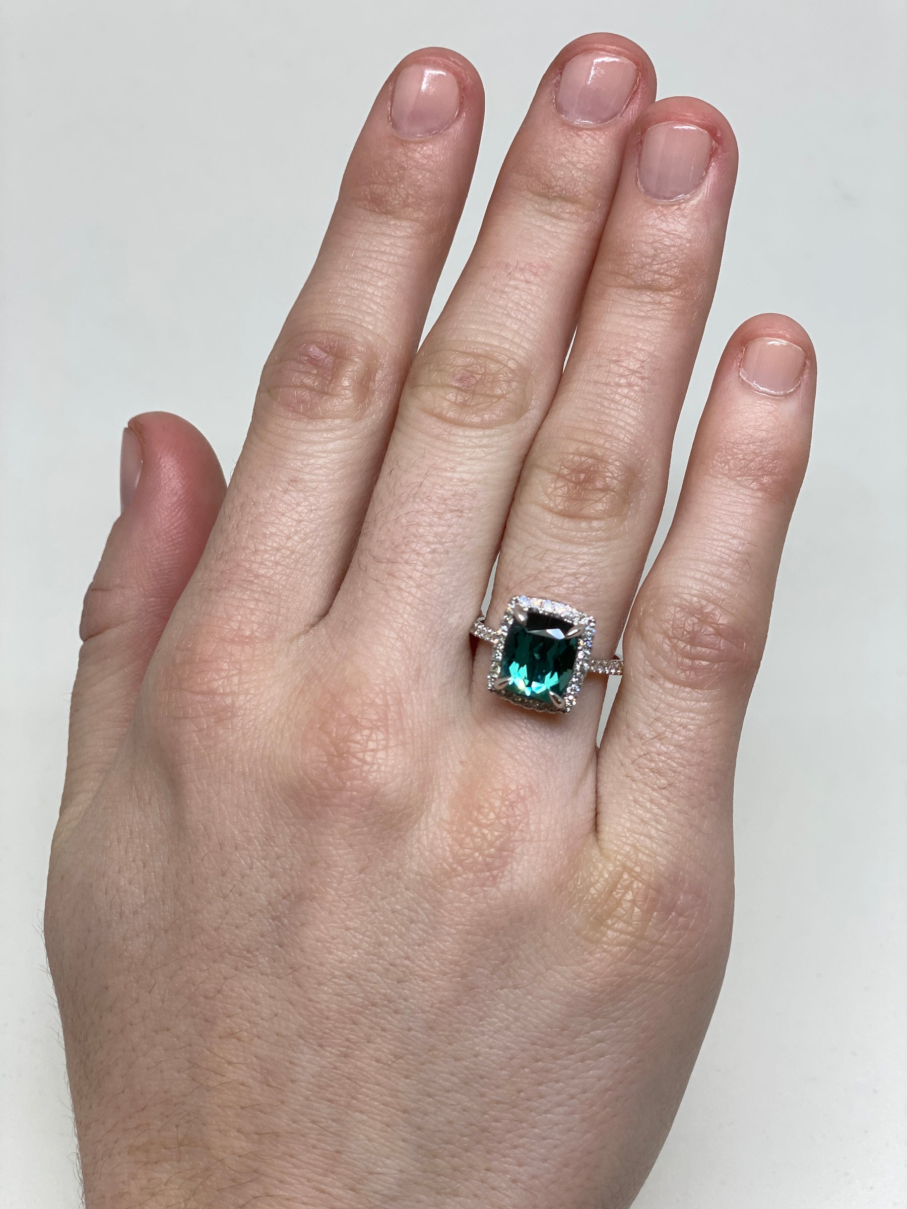 On Model 14k White Gold Green Cushion Cut Tourmaline in a diamond halo and accented band